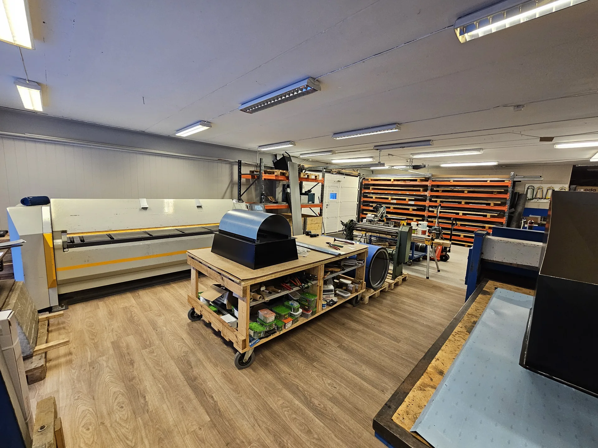 Moderne CNC-kantemaskin og fargesortert blikklager i verkstedet