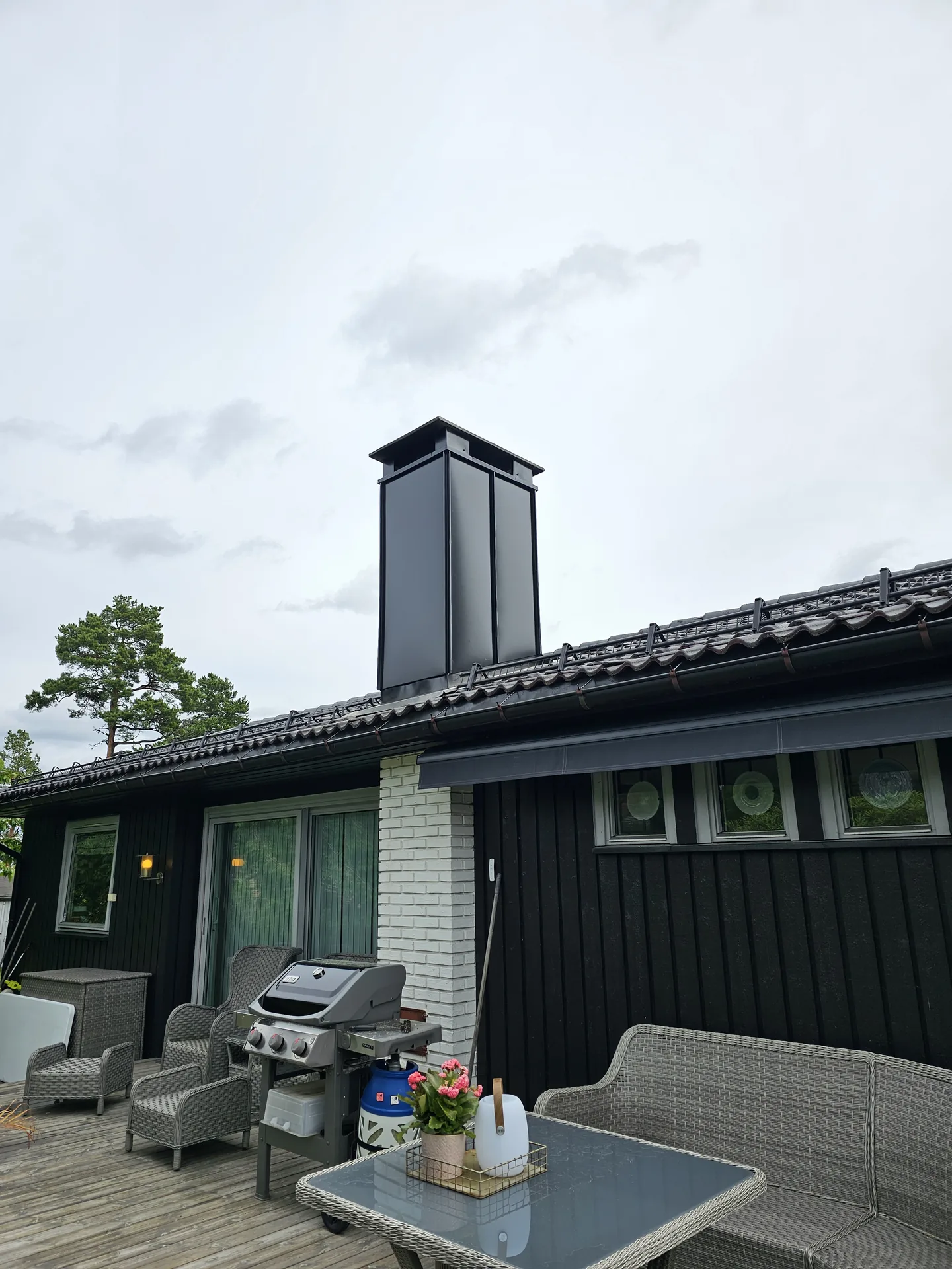 Heldekkende pipebeslag i sort på enebolig – pipa kledd inn av HM Blikk AS